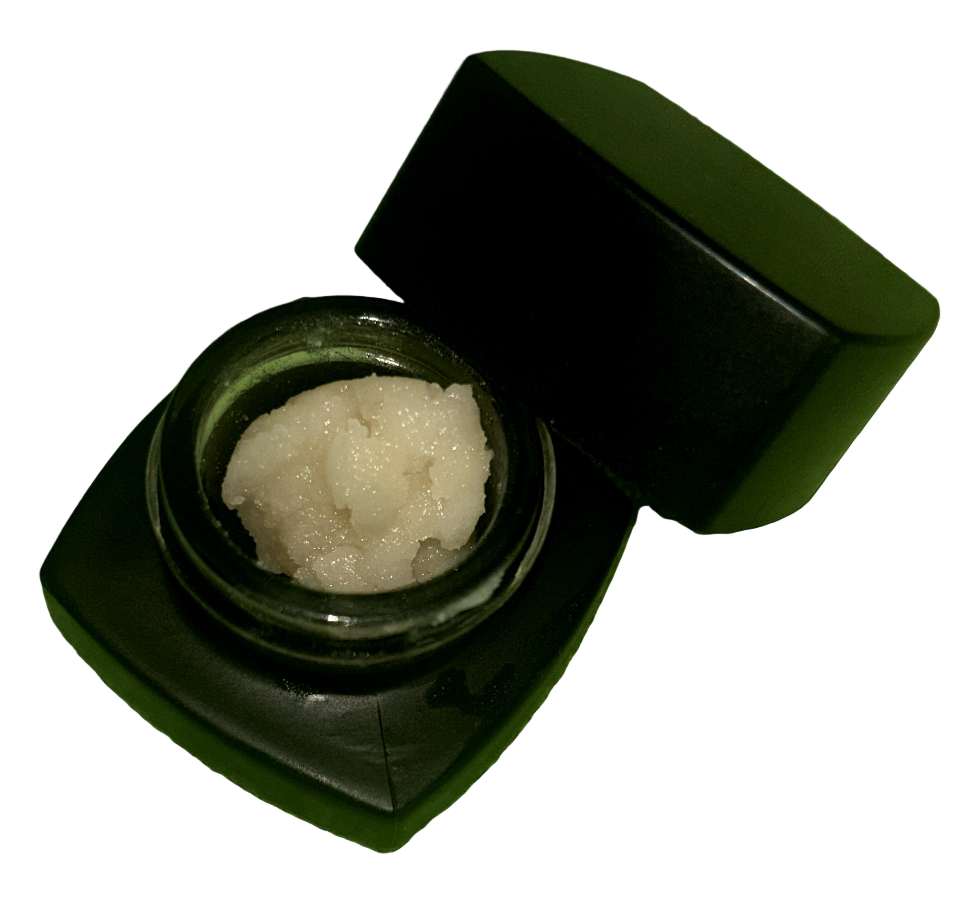 Black container with a white substance on a green surface